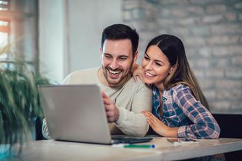 Young Couple Using Laptop On Desk At Home at Renaissance Park Apartments, Davis ,36305